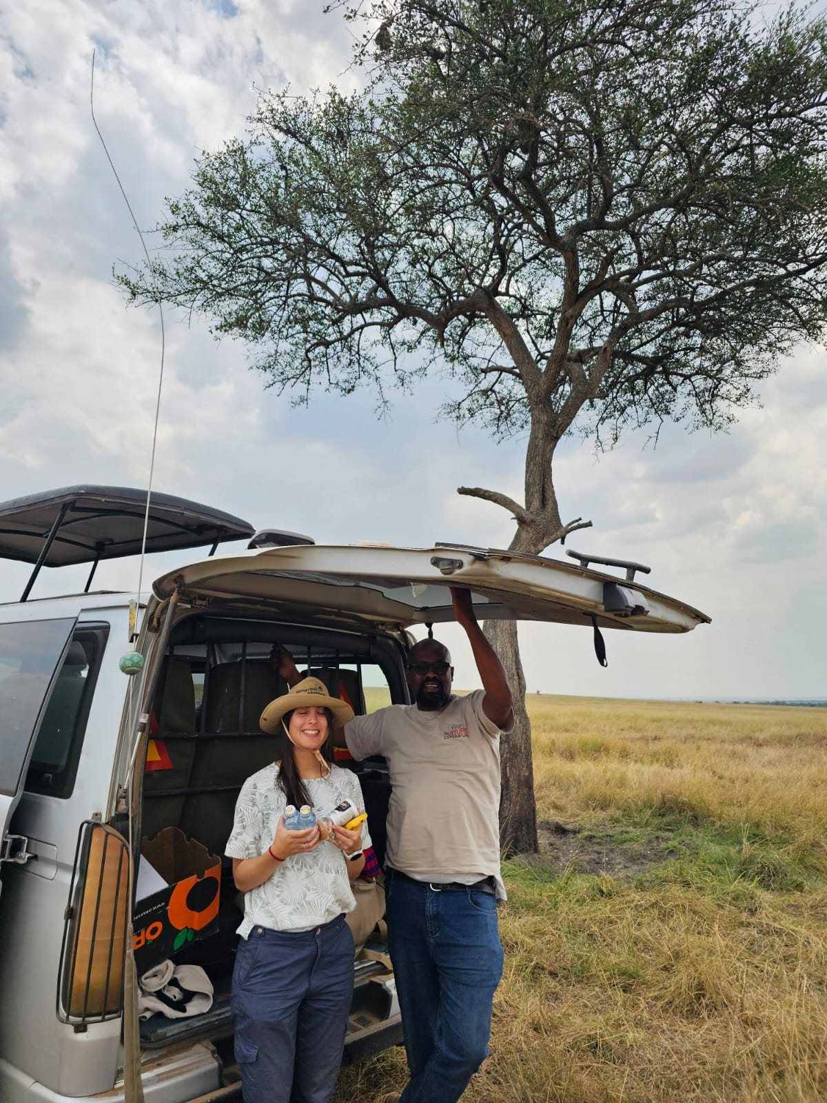 A Mzingo guide and a guest beside the safari vehicle