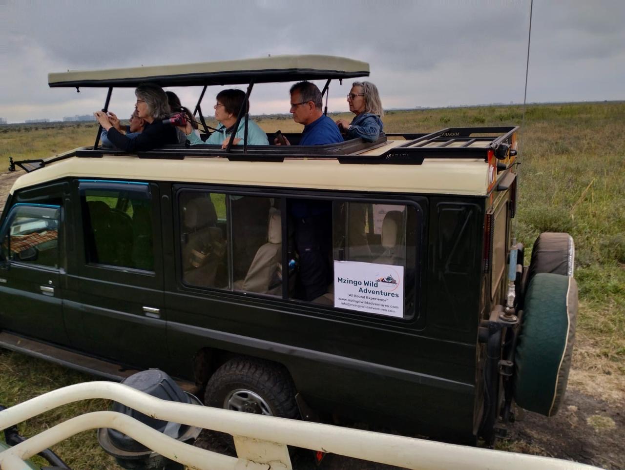 Guests aboard a Mzingo safari vehicle on the savanna